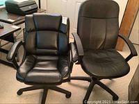 Two black office chairs shown side by side on a carpeted floor. The left chair is high-backed with segmented padded cushioning. The right chair is mid-backed with smoother padding and notable damage on the left armrest.