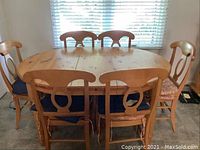 Six chairs arranged around oval table in front of window