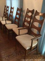 Six chairs in a row showing wood frames and fabric seats