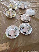 Photo showing pairs of vintage teacups and saucers in floral patterns from Royal Albert and Royal Grafton brands arranged upside-down on saucers