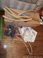 Photo of wooden hangers, Deluxe pillow speaker, and Sony Walkman with wiring and additional items on a floor and couch.