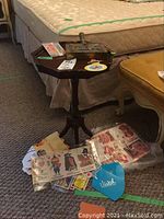 Small dark wooden octagonal table with folded vintage McDonald's valentines and collectibles displayed on and around it, including paper valentines, cookie boxes, and temporary tattoos.
