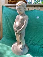 Full view of the life size boy sculpture showing standing pose and base