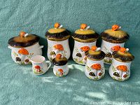 Overview of full set: stock pot, three tall canisters, small jar and creamer