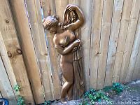 Full view of the vintage large wall sculpture relief showing the nude female figure standing beside a draped cloth.