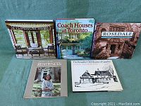 Five hardcover coffee table books on homes and architecture displayed upright on a green fabric background, titles clearly visible.