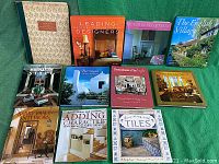 Full view of all 11 hardcover books with titles visible, arranged on a green surface.