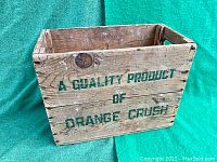 Front side showing 'A QUALITY PRODUCT OF ORANGE CRUSH' green text on aged wood surface