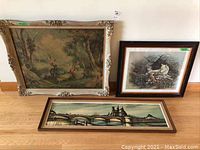 Three framed prints arranged on floor showing variety of subjects and sizes