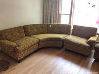 Full view of three piece sectional sofa arranged by a window on wood floor