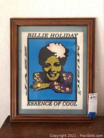 Framed print with a colorful stylized portrait of Billie Holiday, text includes 'Jazz Music' and 'Essence of Cool'. Whole print and frame visible.