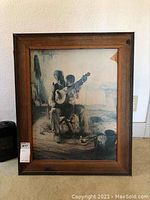 Framed print titled 'The Banjo Lesson' in a wood frame with visible break at top right corner