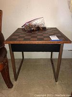 Full view of wooden chess board table with chess pieces in plastic bag on top