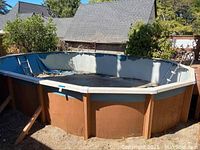 Photo of round above ground swimming pool showing intact frame with no liner, outdoor setting