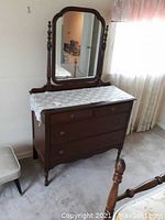 Front angle view of the vintage wooden dresser with mirror, showing all drawers and lace runner on top under the mirror.