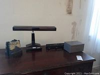 Photo showing the entire desk with all items: vintage desk lamp, Mt Rushmore bookends, photo poster and a small box.