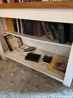 Shelf with books on psychology, zoology, cake decorating showing multiple titles and bindings, some stacked horizontally.