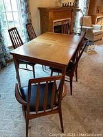 Full view of teak dining table with six chairs around