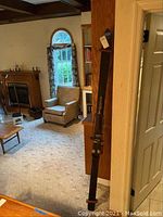 Photo showing one ski leaning against a wall and part of the living room background.