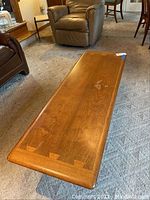 Full view of coffee table showing overall shape, finish and surface wear.