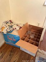 Box containing multiple glass punch cups arranged in individual slots, partially opened.