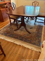 Full view of the area rug under a dining table, showing size, color, and pattern.