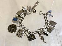 Full view of the silver charm bracelet with multiple attached charms.