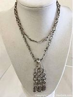 Full view of the mid century Taxco necklace on display stand showing chain and pendant.