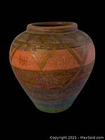 Front angle view of the terracotta planter showing geometric designs and colors on black background