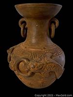 Front view showing fish motif and looped rings on neck of terracotta planter.