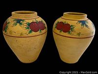 Front view of the pair of terracotta planters with harvest fruit and floral design, beige base color