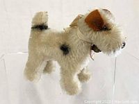 Front side view of the fox terrier plush showing the fur texture, coloration, and button in ear.
