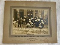 Full view of sepia-toned photograph depicting rural mail carriers posed outside Clinton post office in 1913 Christmas scene, mounted on cardboard.