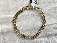 Full view of the 14K gold charm bracelet laid flat showing double-link chain and spring ring clasp