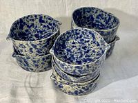 Stack of six blue speckle bowls with spouts, showing speckled pattern and bowl shapes