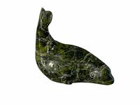 Front angled view of the green whale carving showing shape and texture.