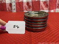 Stack of five round mercury glass coasters with shiny silver reflective surface.