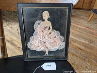 Full view of the framed silk collage artwork showing a woman in a ball gown, against a black background.