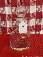 Front view of the vintage glass decanter showing clear glass construction, hexagonal base, and stopper.