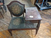 Side view of the telephone table showing the attached wooden writing surface and upholstery.