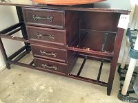 Front-left view of wood dresser showing four drawers on left and open frame on right for baskets.