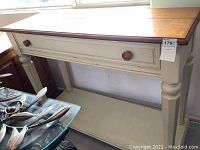 Front left angle view of the media stand showing drawer and lower shelf