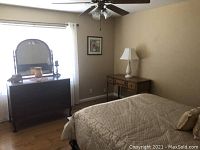 Full view of the dresser with attached mirror in a bedroom setting.