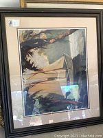 Photo showing the full framed art print depicting three sailboats with sails in muted beige and brown tones, dark wood frame with dual matting.