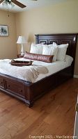 Full view of dark wood bed frame with headboard, footboard, and indoor bedroom setting