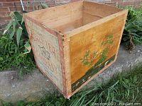 Angled side view showing wooden box with painted graphics and wood grain