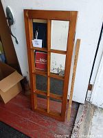 Full frontal view of the wooden window frame mirror, showing eight individual mirror panes, the wooden frame, and the size comparison with a measuring stick beside it.