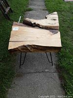 Side view showing thickness of live edge wooden slab and metal hairpin legs.