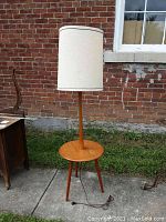 Full view of teak floor lamp with integrated round table and off-white drum shade