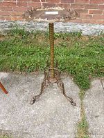 Full view of the round top and three-legged base on concrete surface showing overall structure and height.